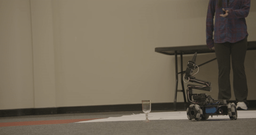 LeKiwi robot picking up a plastic wine glass
